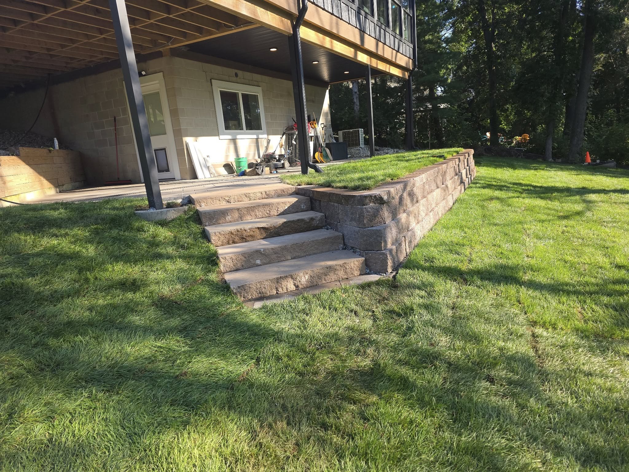 Retaining wall and steps beside a finished lawn