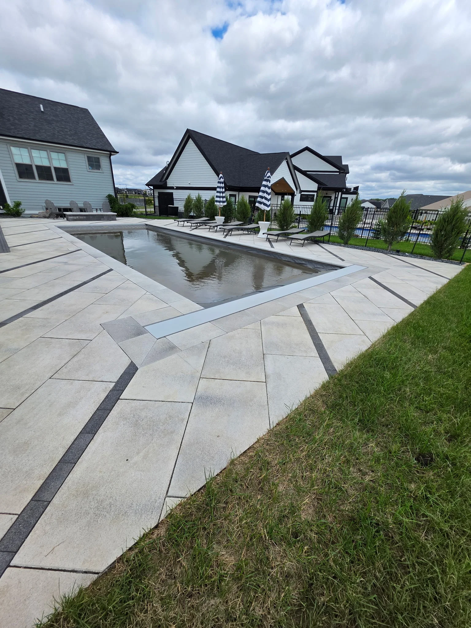 Finished pool, patio, lounge area, and landscaped backyard